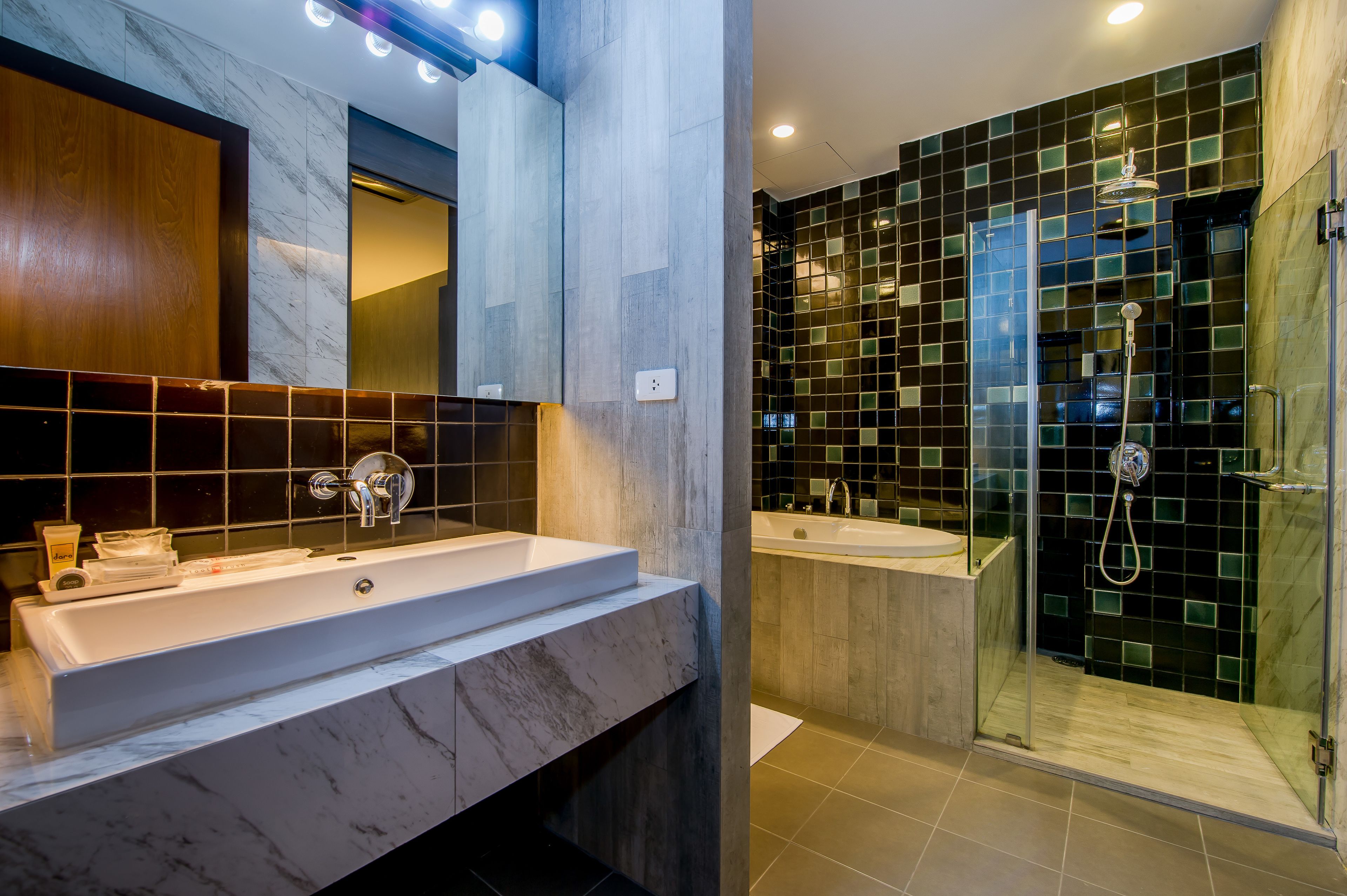 A modern bathroom with a large sink, a mirror, and a glass-enclosed shower area.