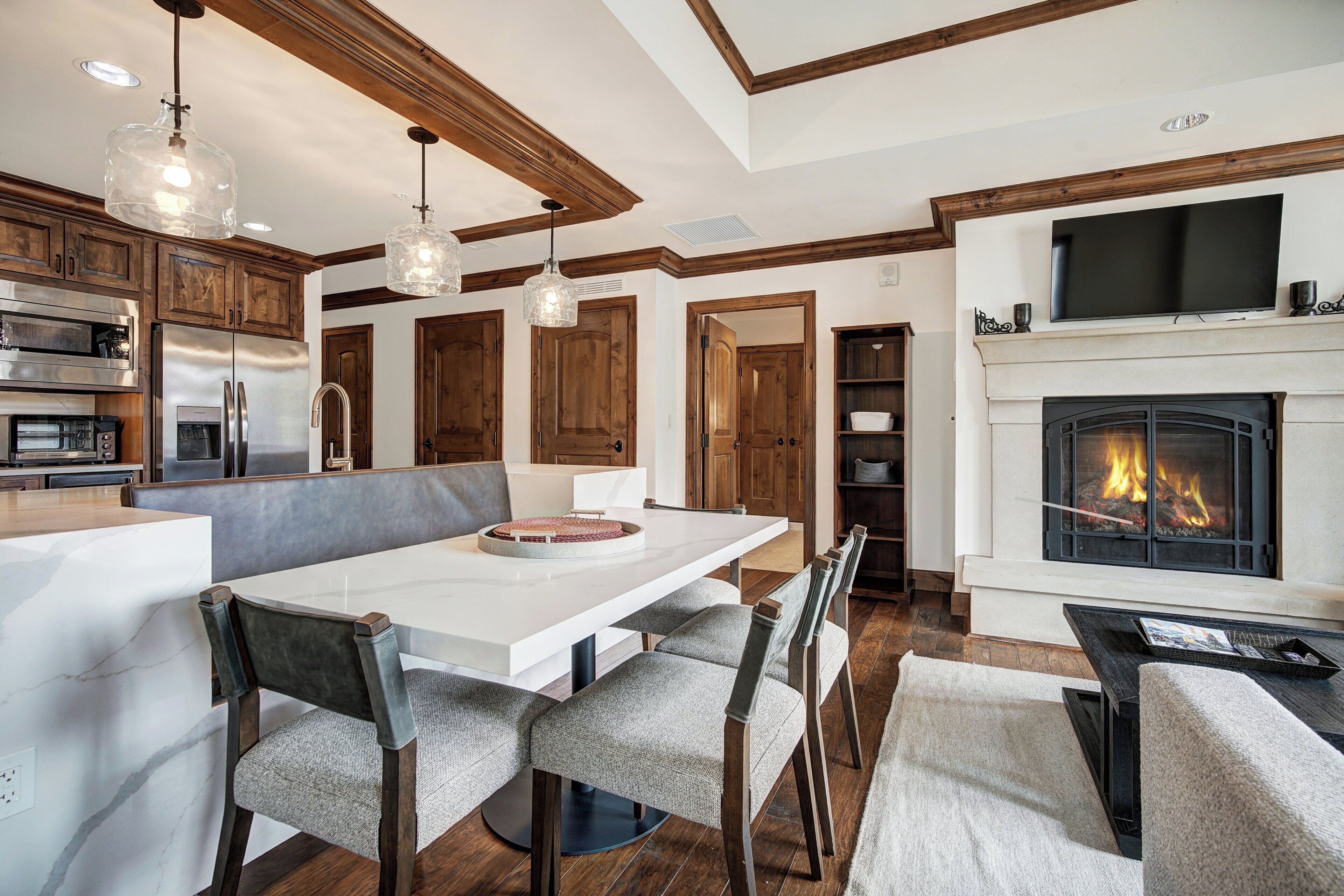 A modern kitchen with wooden cabinets, a stainless steel refrigerator, and a built-in oven.