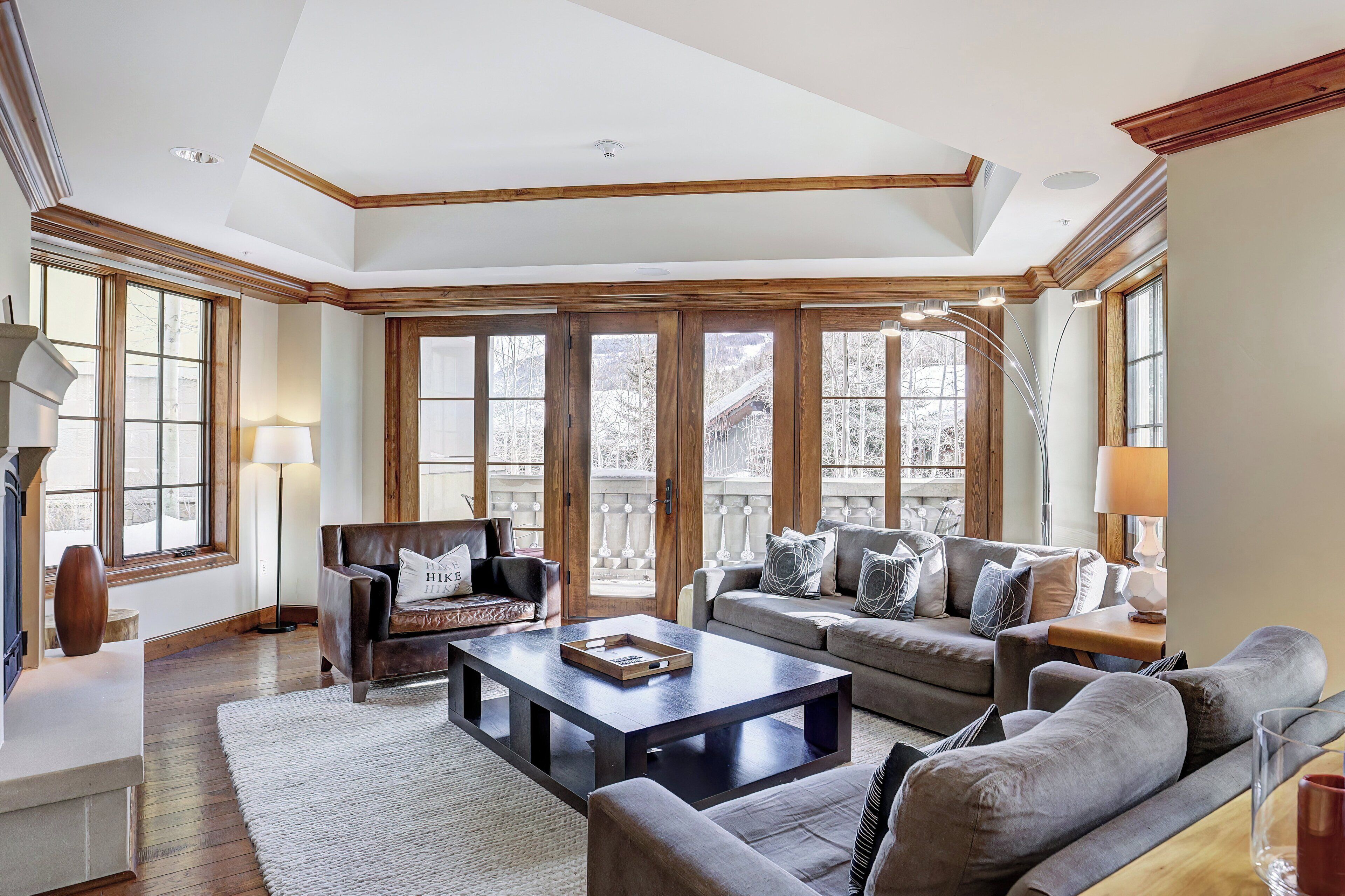 A spacious living room with a large window, a fireplace, and a cozy seating area.