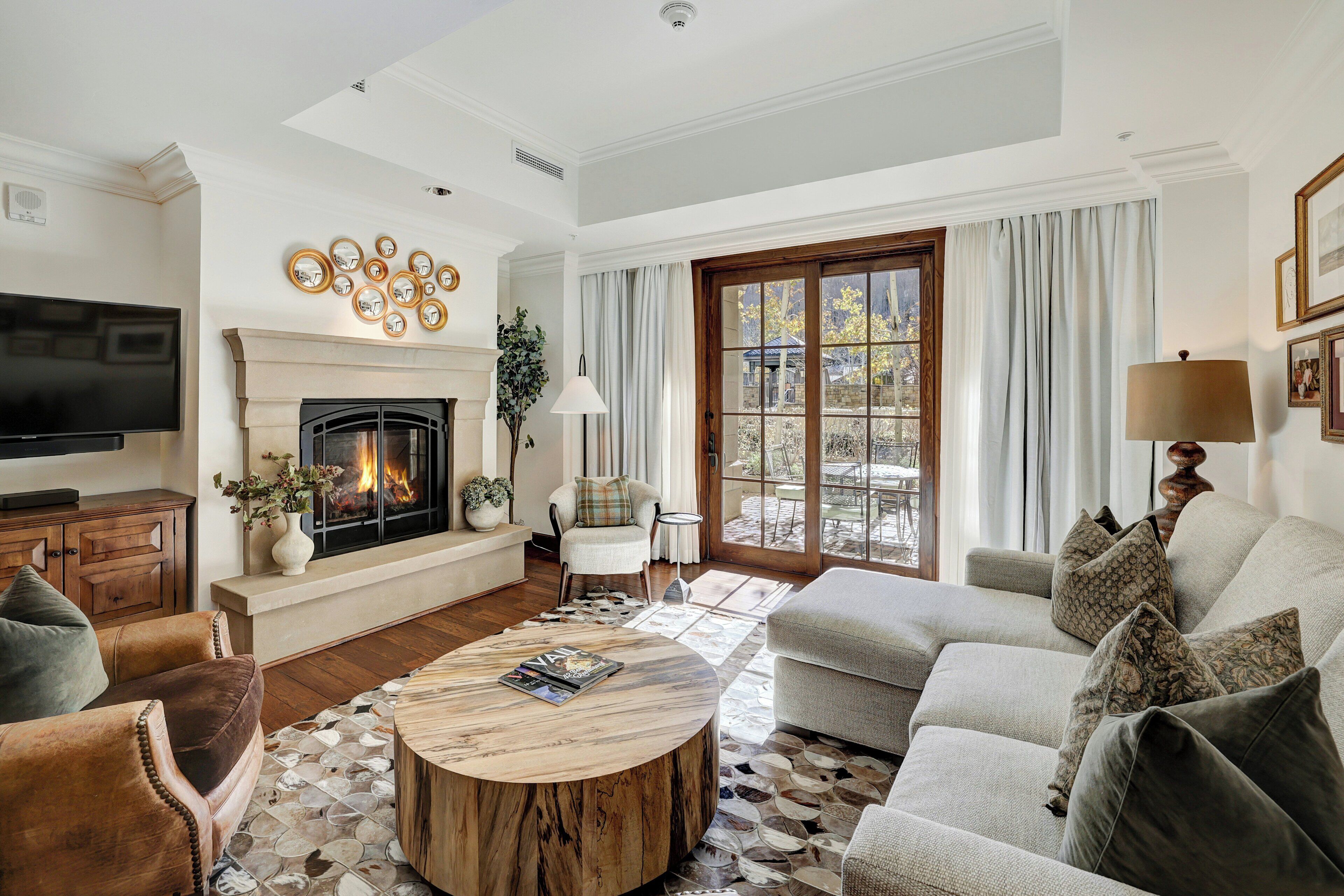 A living room with a fireplace, sofa, coffee table, and television.