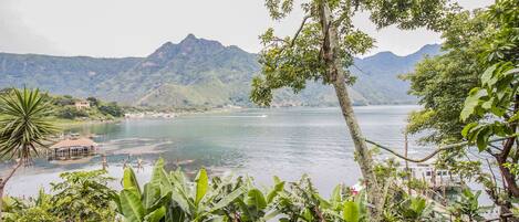 Un paisaje tropical con un lago, montañas y vegetación exuberante.