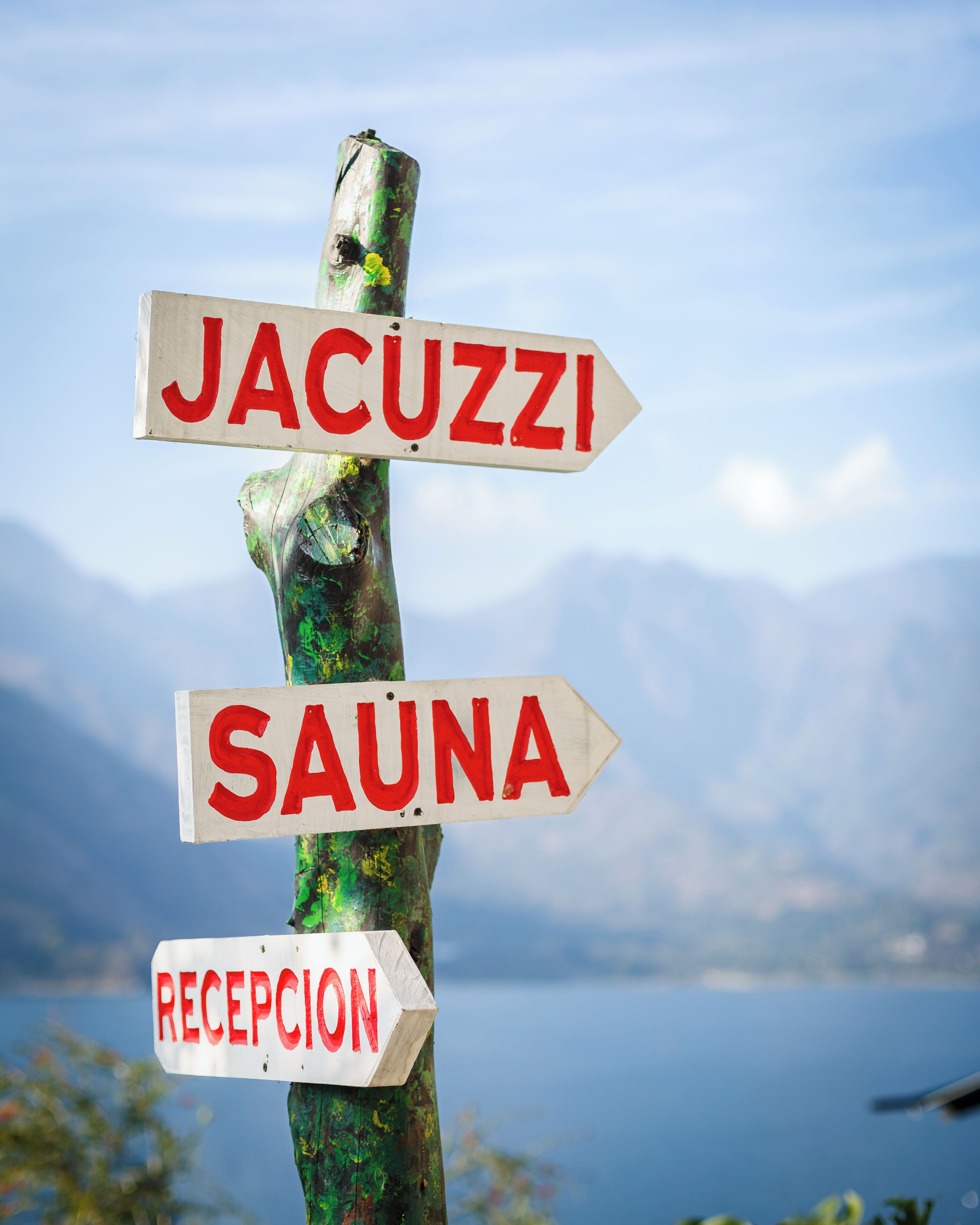 A directional signpost with 'JACUZZI,' 'SAUNA,' and 'RECEPTION' written on it.