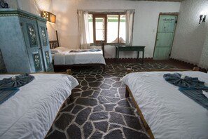 A room with two beds, a stone-patterned floor, a wooden desk, and a wardrobe. - Eco Hotel Uxlabil Atitlan (San Juan La Laguna)