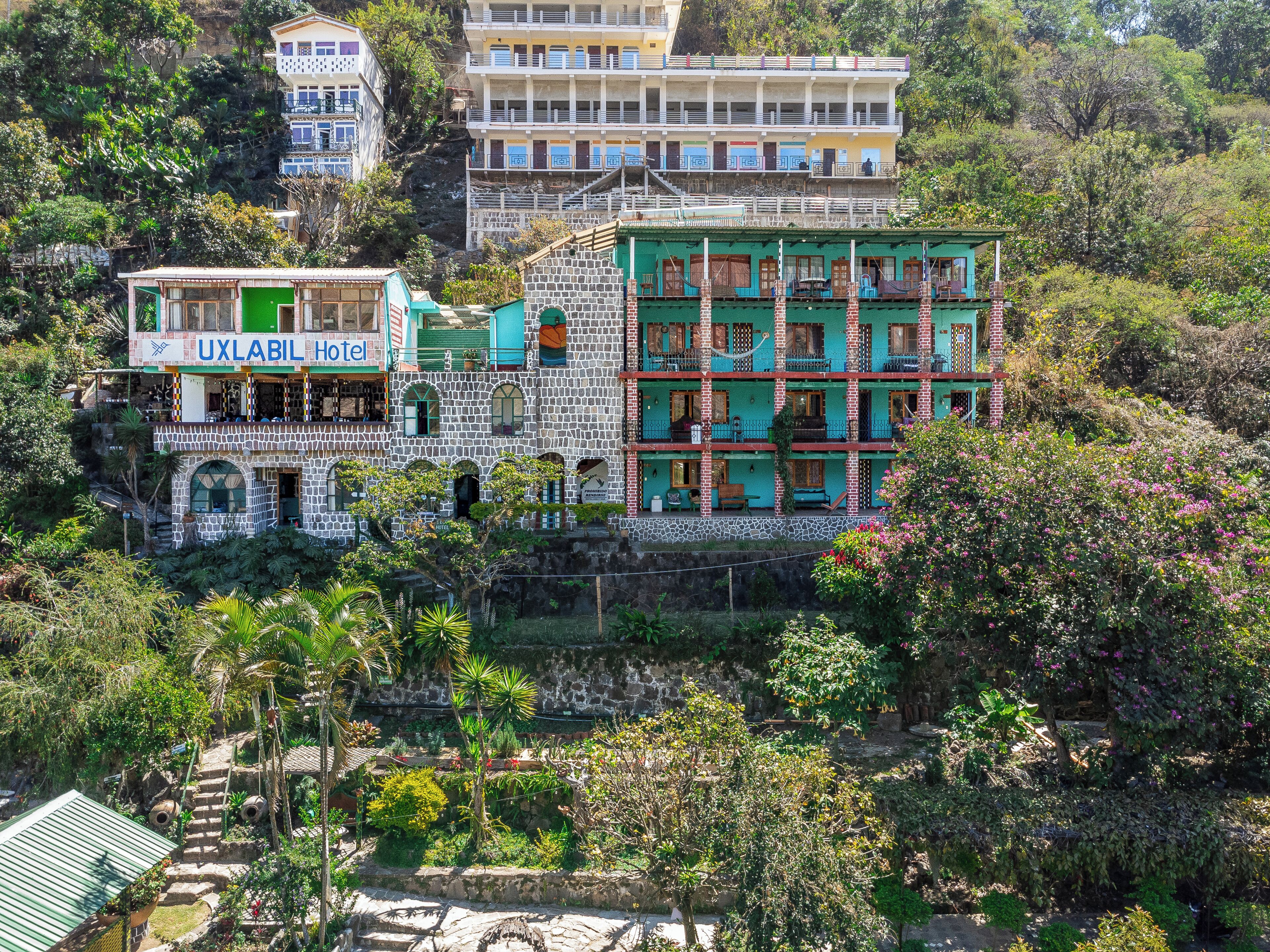 Un hôtel à plusieurs étages, doté d’une façade en pierre et de balcons.