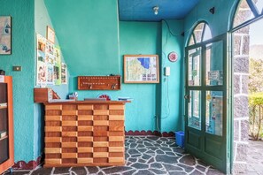 A reception desk with a wooden panel design, a map on the wall, and a green door with glass panels. - Eco Hotel Uxlabil Atitlan (San Juan La Laguna)
