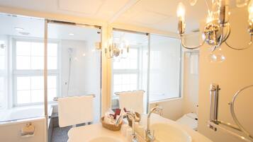 A bathroom with two sinks, a mirror, a chandelier, and a window.