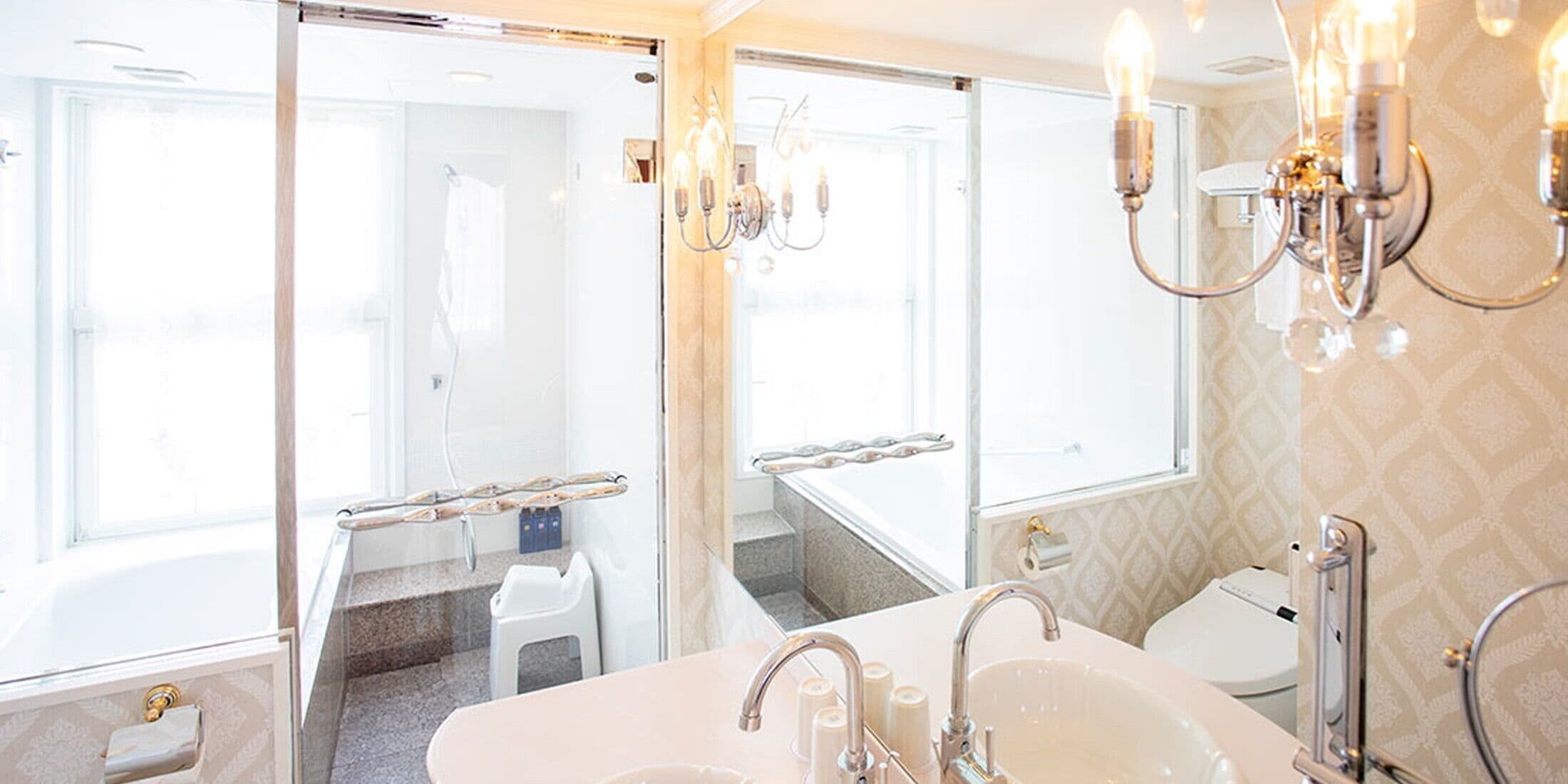 A bathroom with a large sink, mirror, and vanity. There is a shower area visible through a glass door.