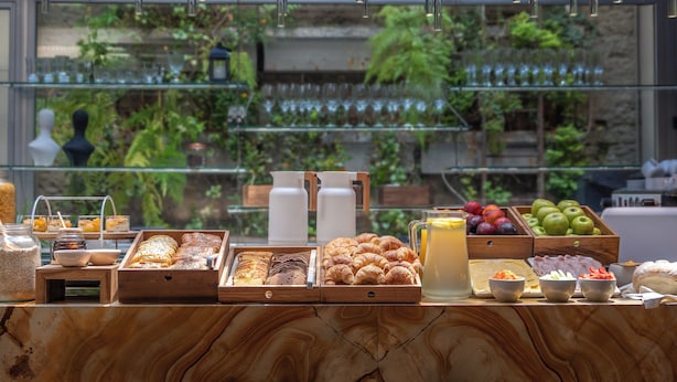 Un bufé de desayuno con diversos pasteles, frutas y bebidas.