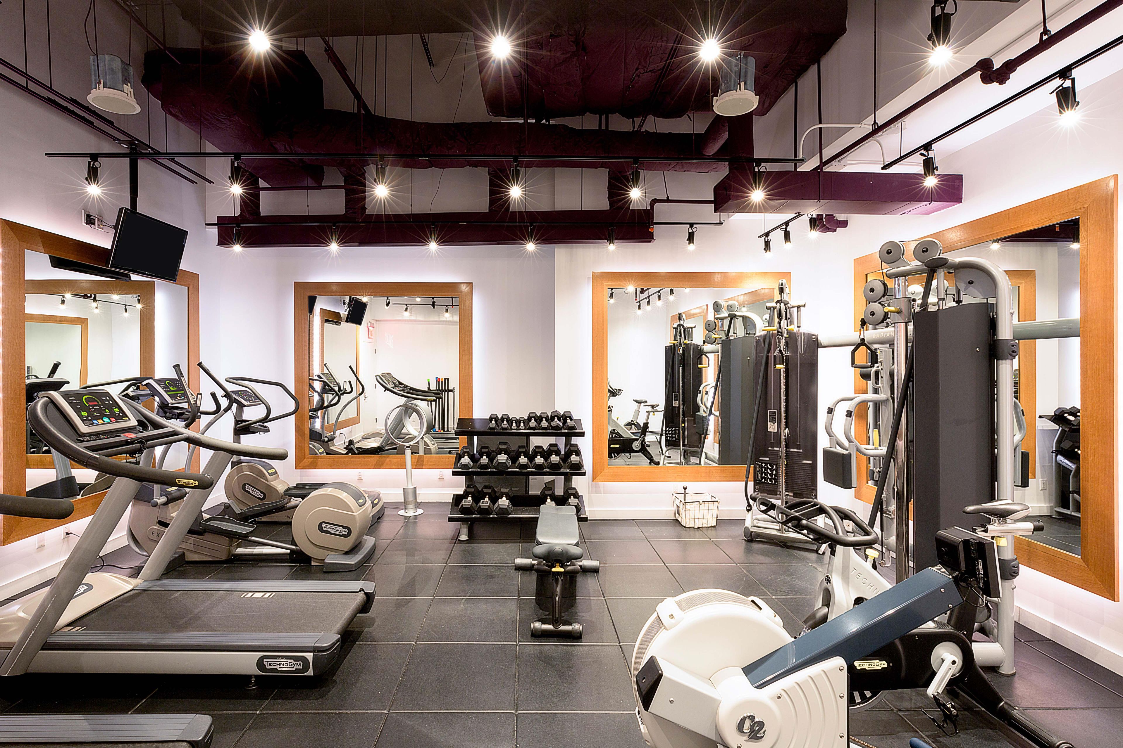 A gym with treadmills, weight machines, and free weights.