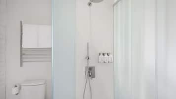 Un baño moderno con cabina de ducha de vidrio, inodoro y barra para toallas.