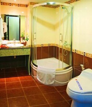 A bathroom with a glass-enclosed shower, a sink, and a toilet.