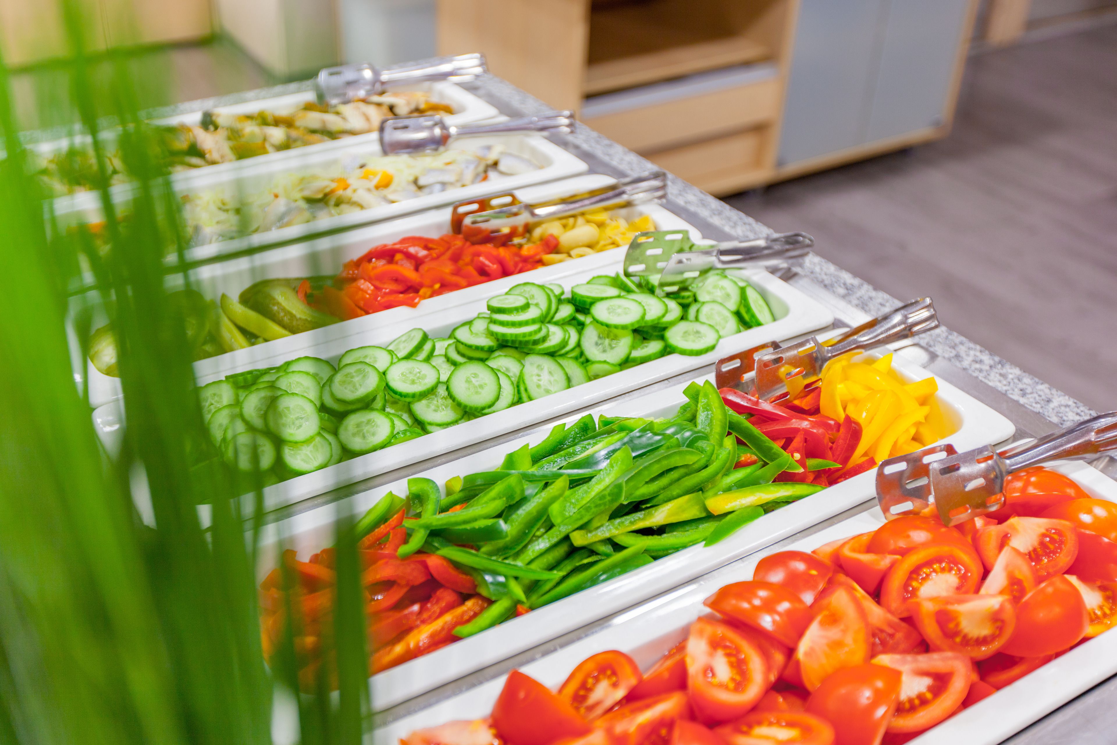 A buffet with various fresh vegetables and fruits.