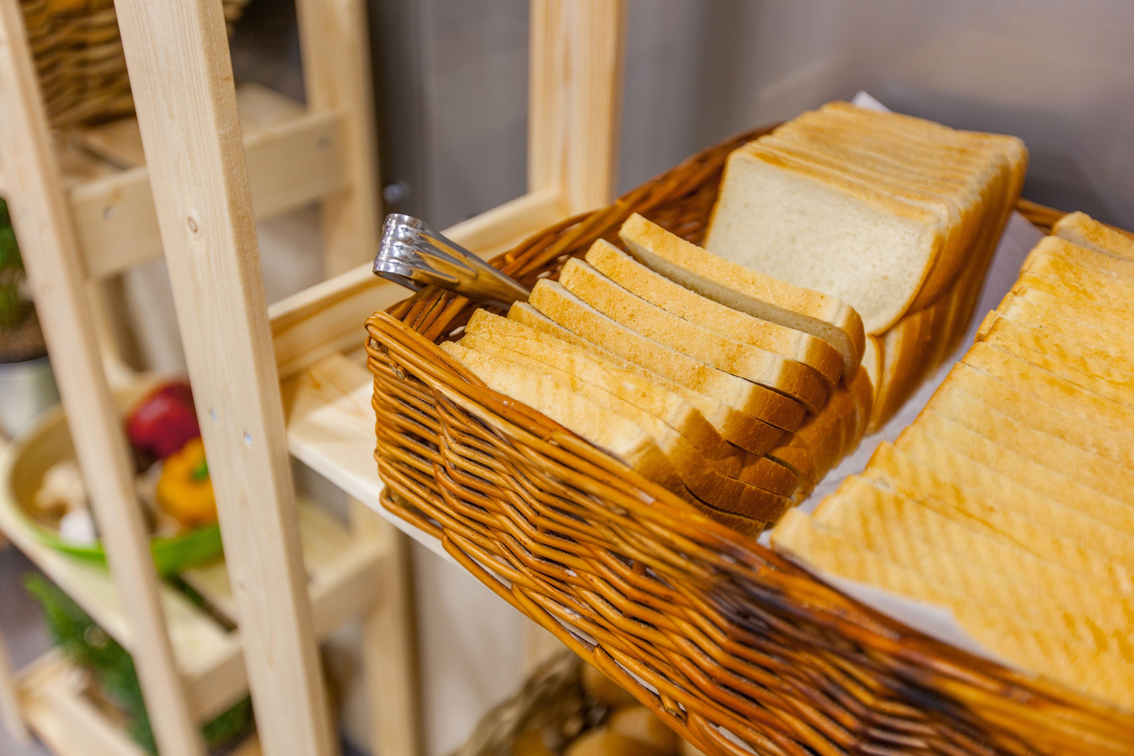 A wicker basket containing several slices of white bread.