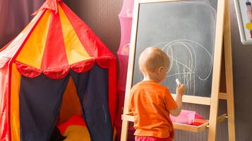 Children can play and learn in this room with a chalkboard, play tent, and educational materials.