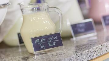 A glass pitcher of soy milk labeled "Mleko sojowe Soy Milk" on a granite countertop.
