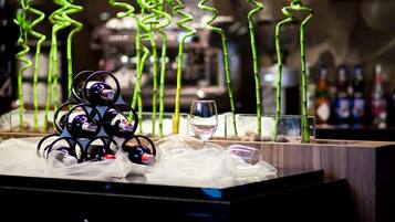 Una zona de bar con una original decoración de bambú, una estantería para vinos y una copa de vino.