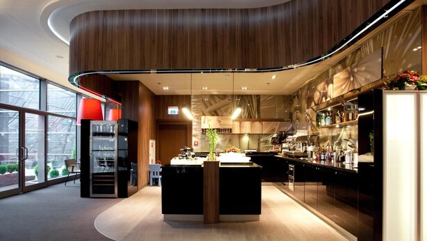 Une cuisine moderne dotée d’un îlot central, d’un coin bar et d’un espace détente offrant une vue sur la ville.