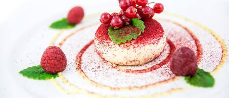A dessert with a raspberry and berry garnish on a white plate.
