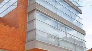 Un immeuble à plusieurs étages, doté d’une façade en briques et de grandes fenêtres.