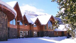 Eine Holzhütte mit mehreren Zimmern, Steinmauern und einer verschneiten Landschaft.