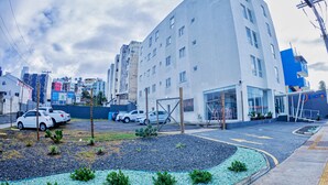 A modern building with a parking area, a small garden, and a visible entrance. - B Hotel (Salvador)