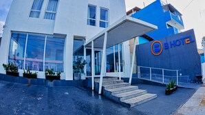 A modern hotel with a blue and white facade, large windows, and a covered entrance area. - B Hotel (Salvador)