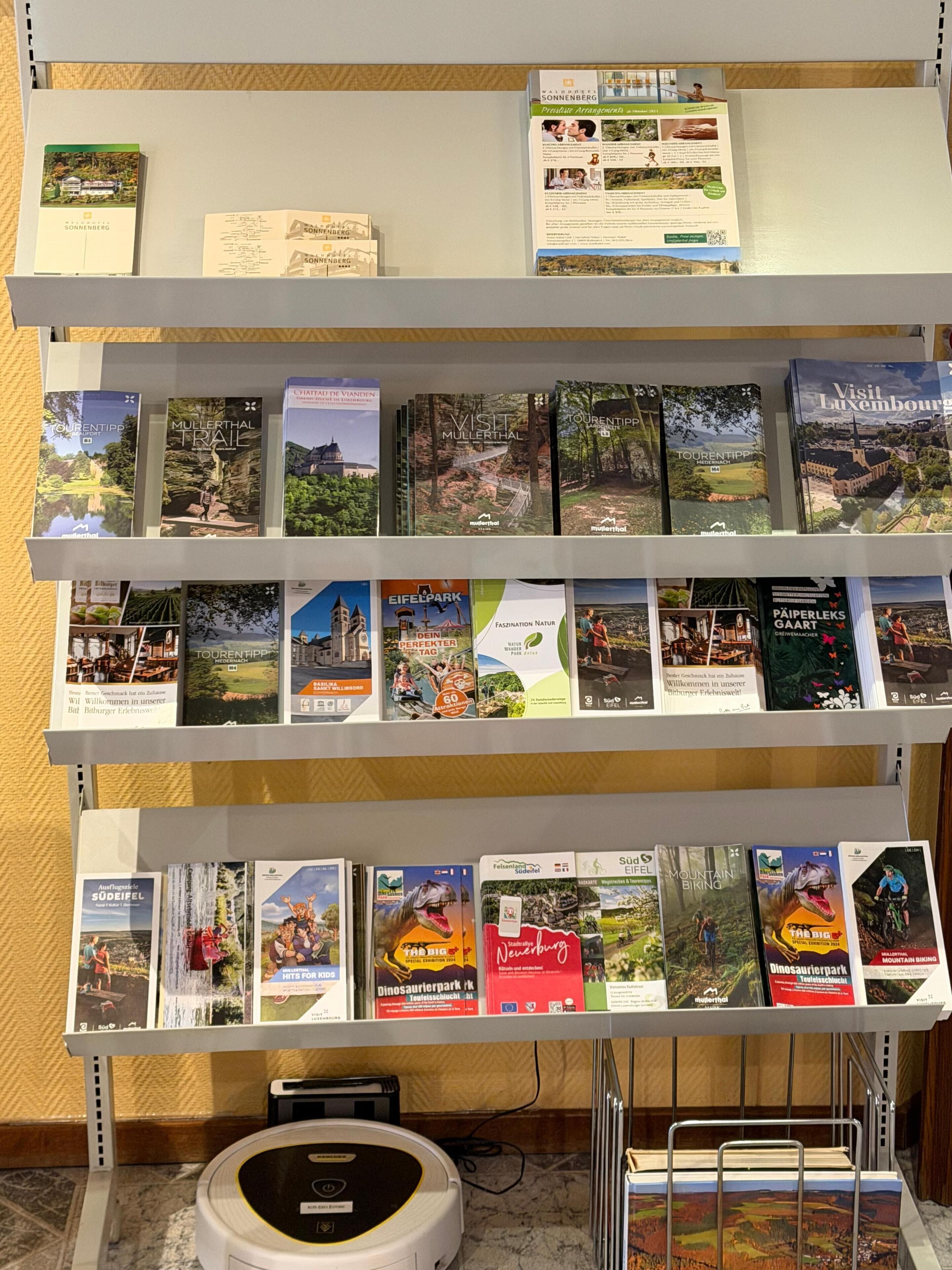 Una estantería con guías de viaje y mapas de diversas regiones.