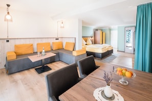 Una sala de estar moderna con un sofá, una mesa de comedor y un cuenco de fruta.