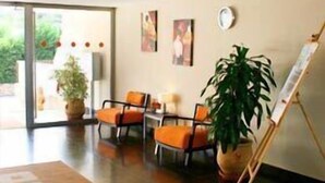 Una habitación moderna con un ventanal grande, un cuadro en la pared y una planta en maceta.