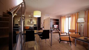 Una habitación de hotel moderna con comedor, cocina y sala de estar.