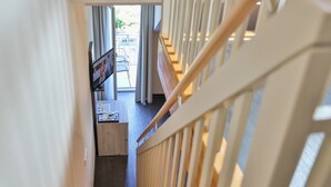 Een houten trap die leidt naar een balkon met uitzicht op de omgeving.