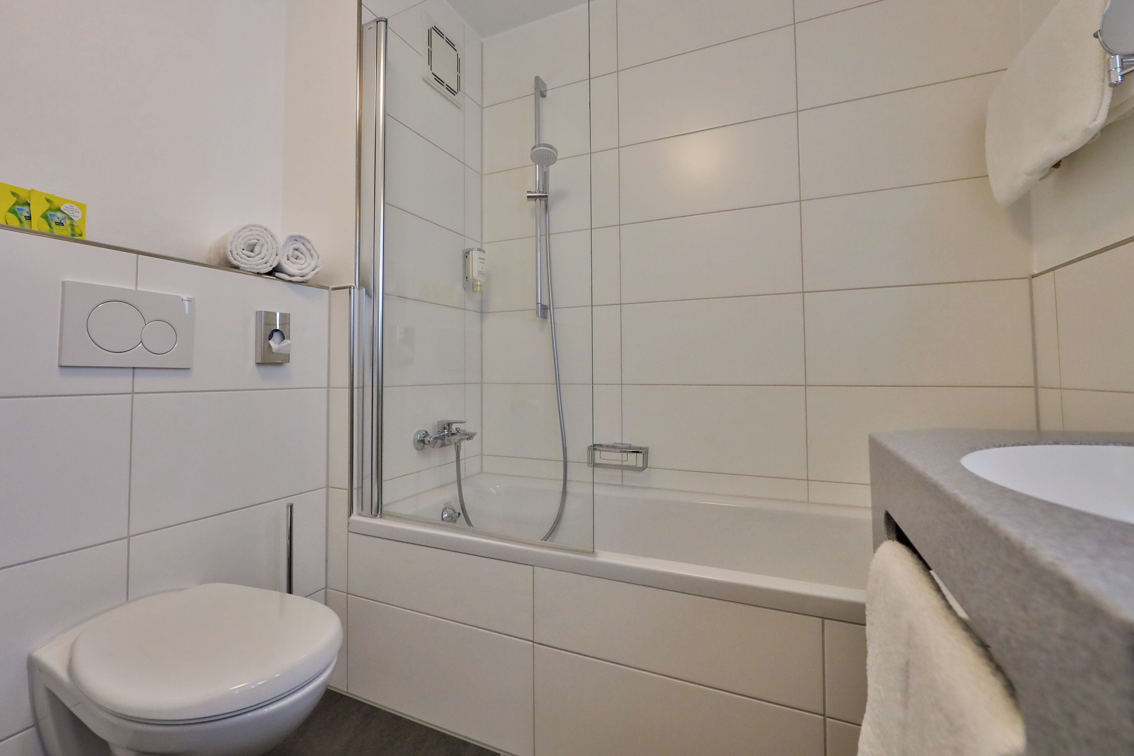 Un baño moderno con inodoro, ducha y bañera.