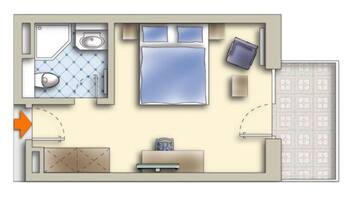 A bedroom with a bed, a bedside table, and a window. There is a bathroom with a toilet, sink, and shower. The room has a door leading to a hallway.