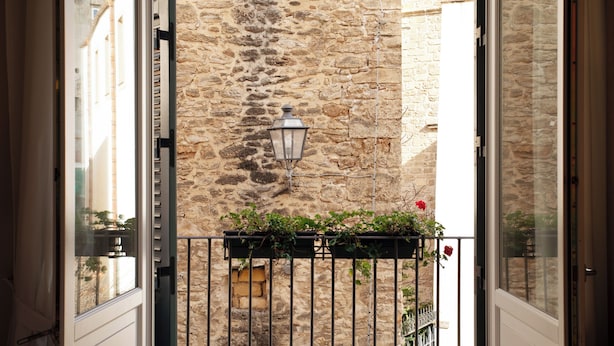 A stone building with a wrought iron balcony railing and a hanging lantern. - Palazzo Brunaccini Boutique Hotel (Palermo)