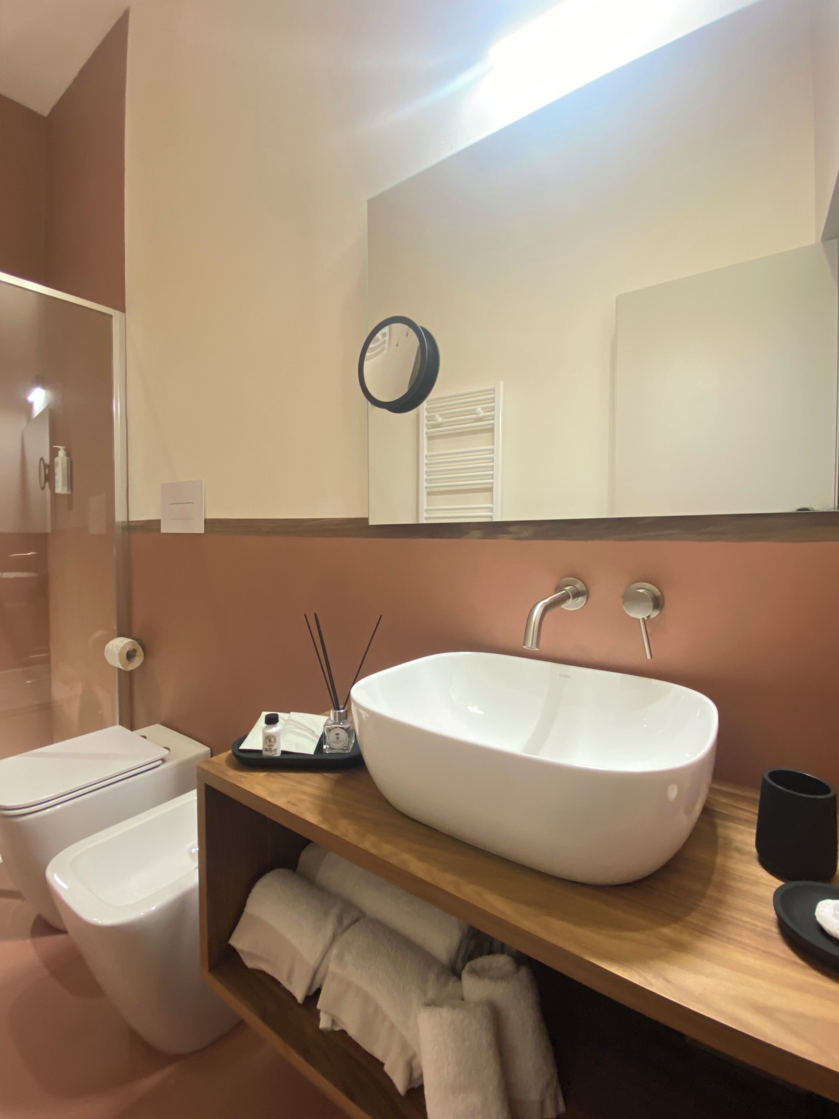 A modern bathroom with a white sink, a mirror, and a towel rack.