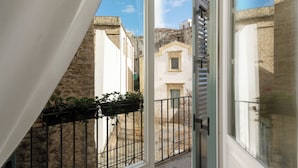A narrow street with buildings on either side, a metal railing, and a clear sky. - Palazzo Brunaccini Boutique Hotel (Palermo)