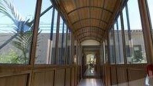 A corridor with wooden paneling and large windows, leading to a building with a modern architectural style. - Hotel Riviera Lido (Milazzo)