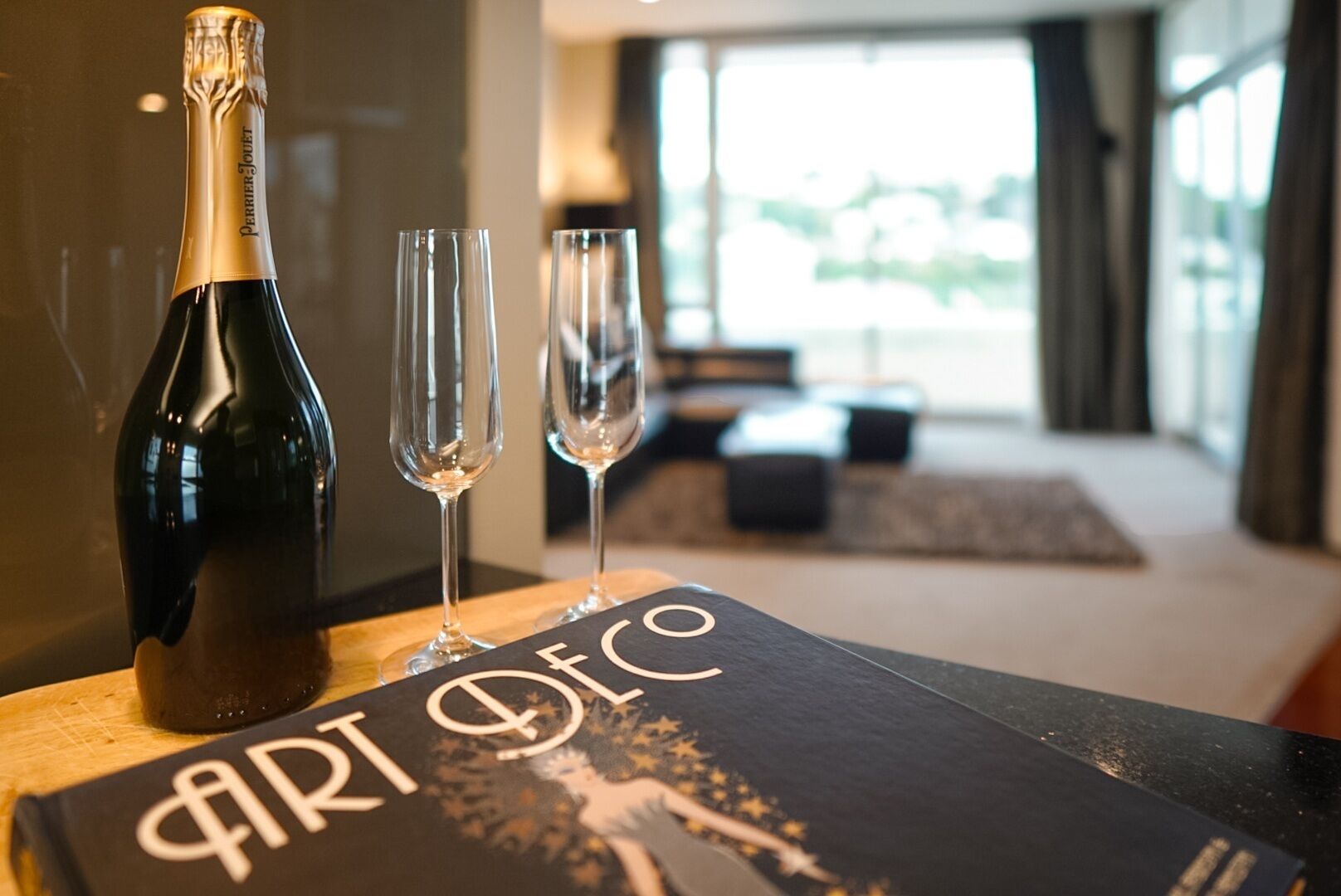 A bottle of champagne and two glasses on a table with a menu titled "ART DECO".