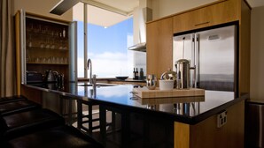 A modern kitchen with a central island, stainless steel appliances, and a wooden cabinet.