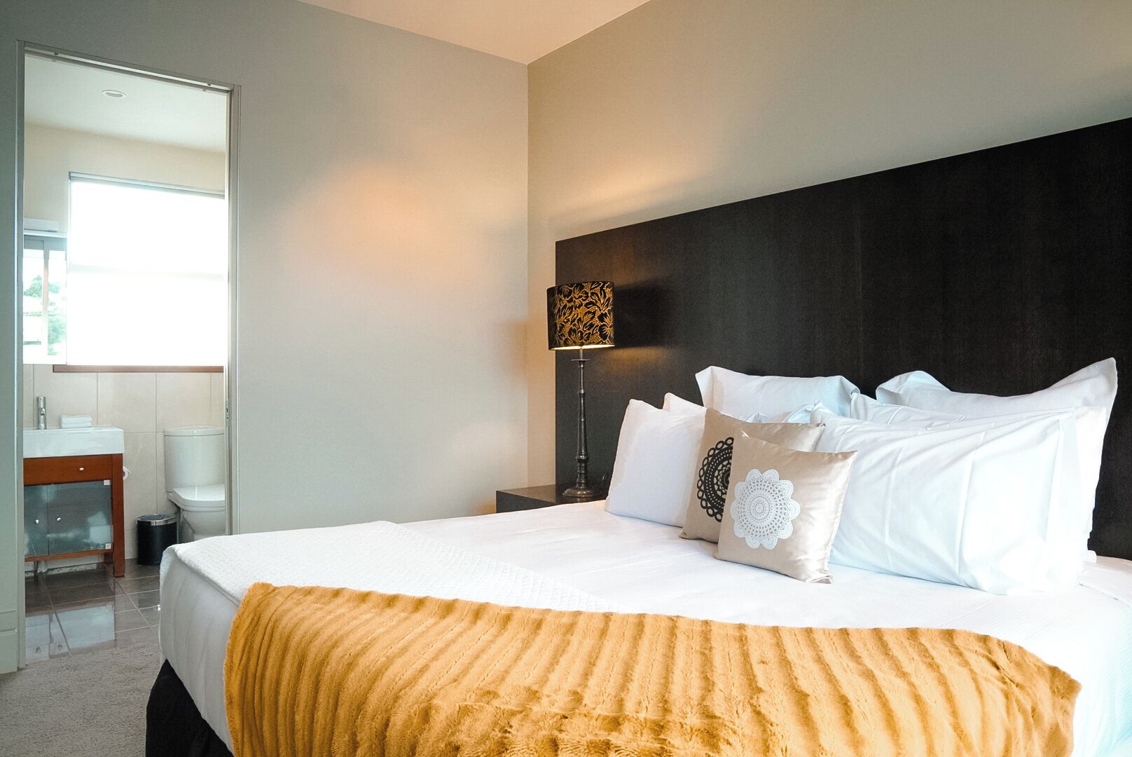 Une chambre d’hôtel avec un grand lit, une lampe de chevet et vue sur la salle de bain.