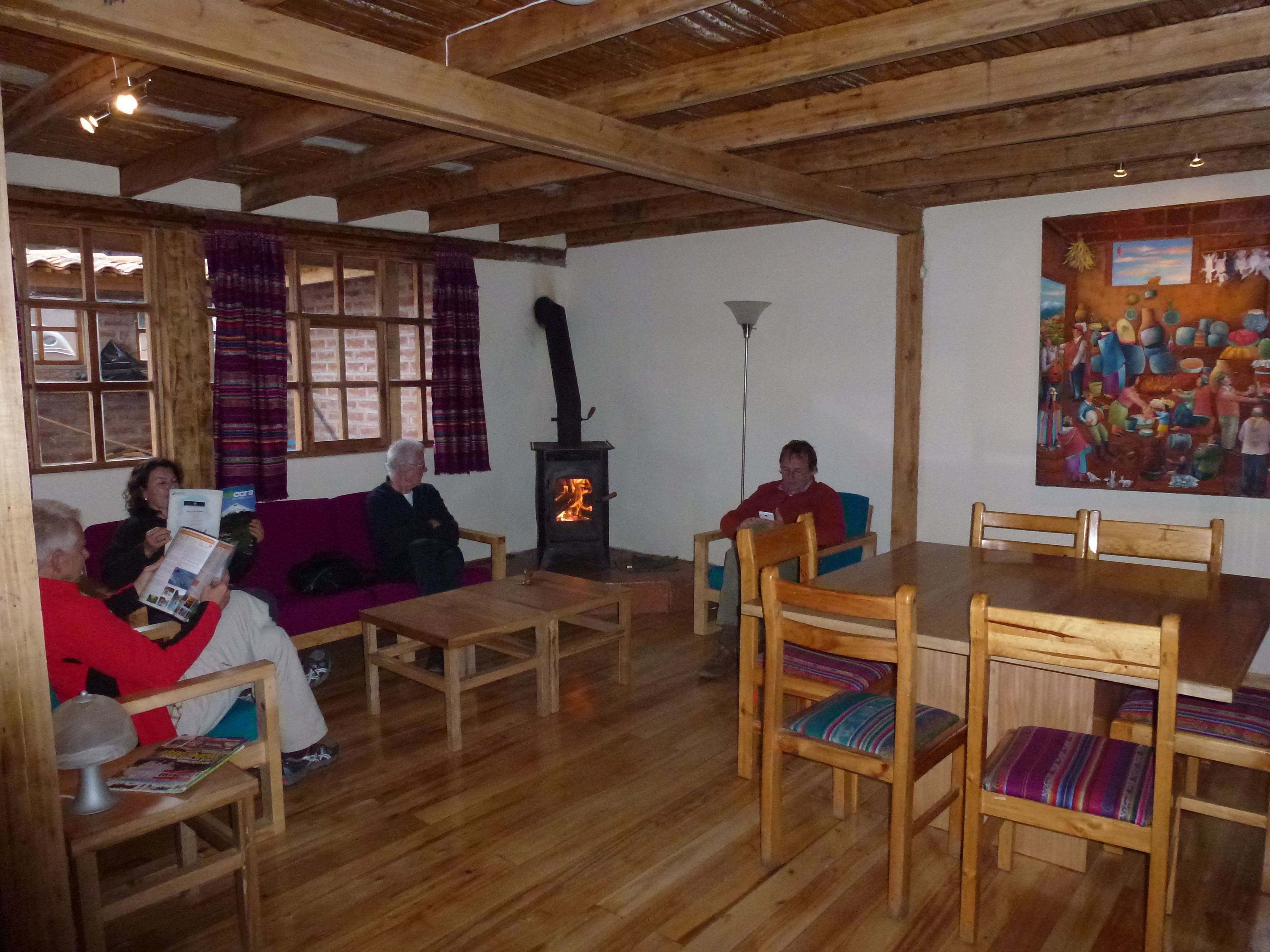 A cozy room with wooden furniture, a fireplace, and a painting on the wall.