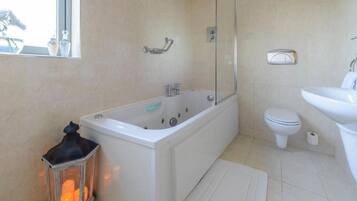 A bathroom with a bathtub, toilet, and sink.