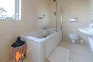 A bathroom with a bathtub, toilet, and sink.