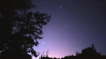 Cielo nocturno con estrellas y luna visible.