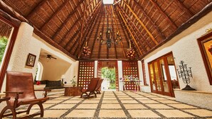 An indoor space with a high, thatched roof, wooden furniture, and a chandelier. - Amarte Maroma Hotel Eco Boutique Spa (Playa del Carmen)