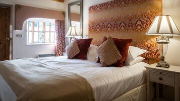 A well-lit bedroom with a large bed, two bedside lamps, and a patterned wall.