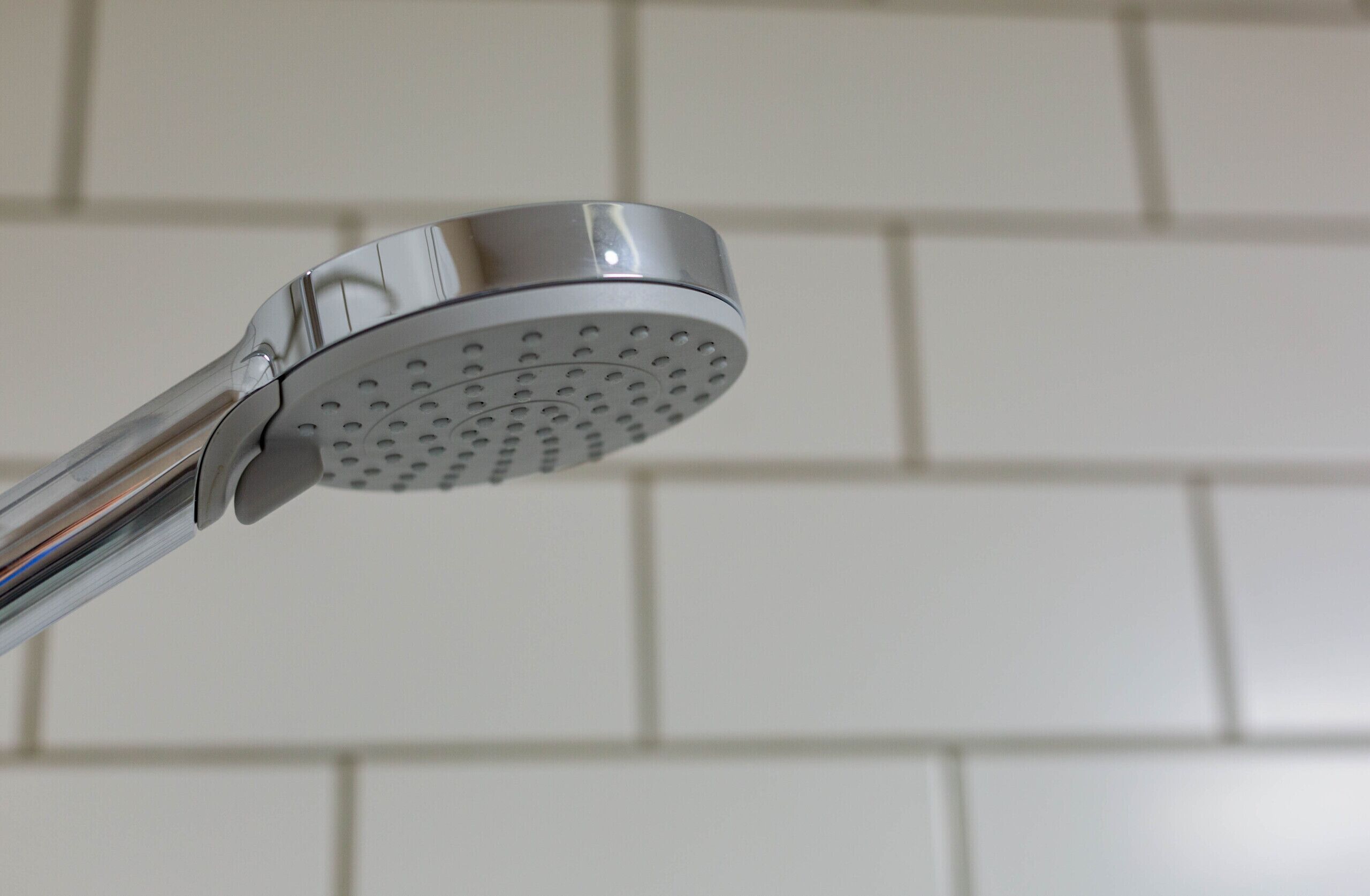 A modern showerhead with a circular design and multiple water nozzles.