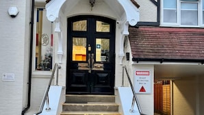 A building entrance with a black double door, white steps, and a warning sign indicating a height restriction of 2 meters. - Gidea Park Hotel (Romford)