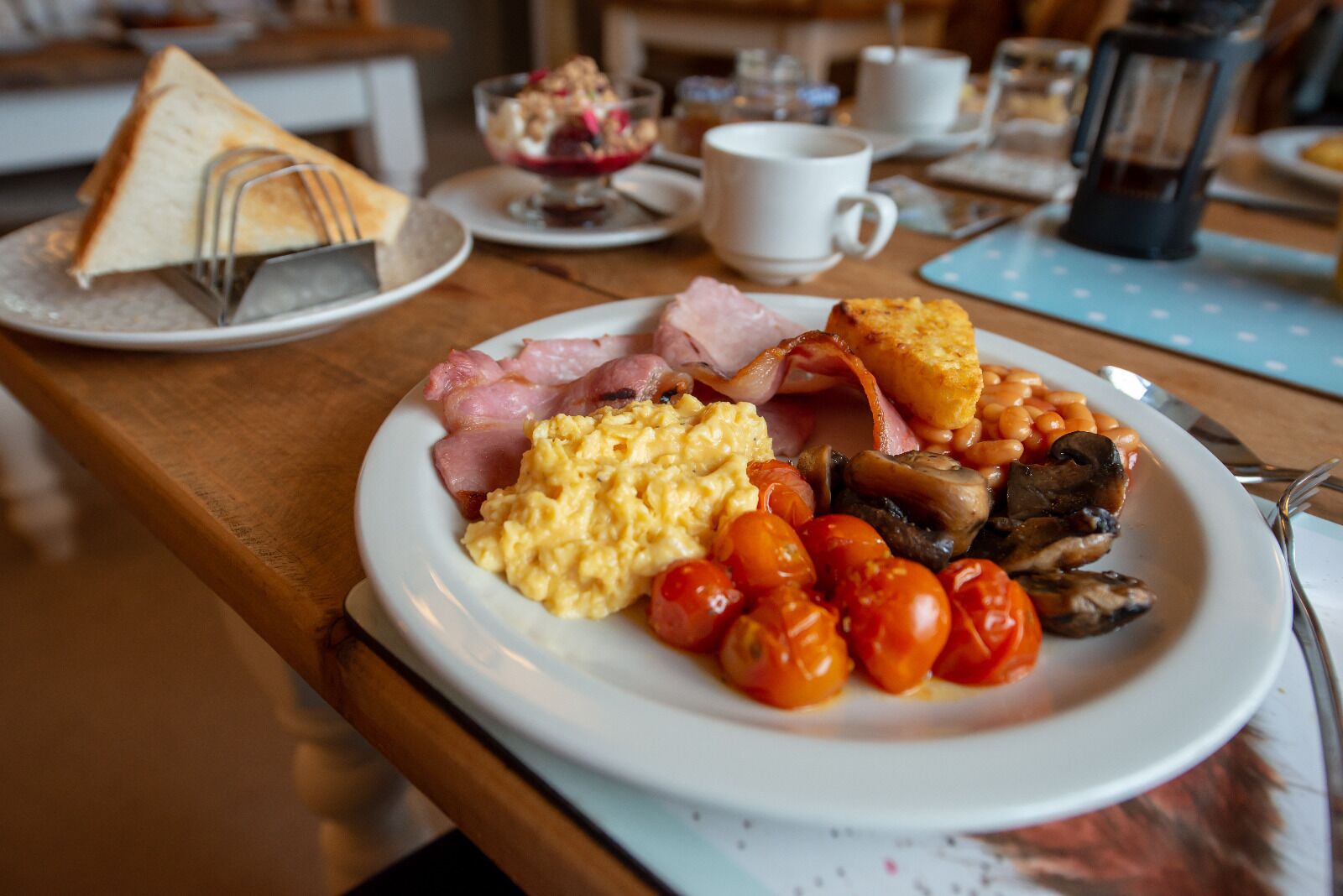 A breakfast plate with eggs, bacon, mushrooms, and tomatoes.