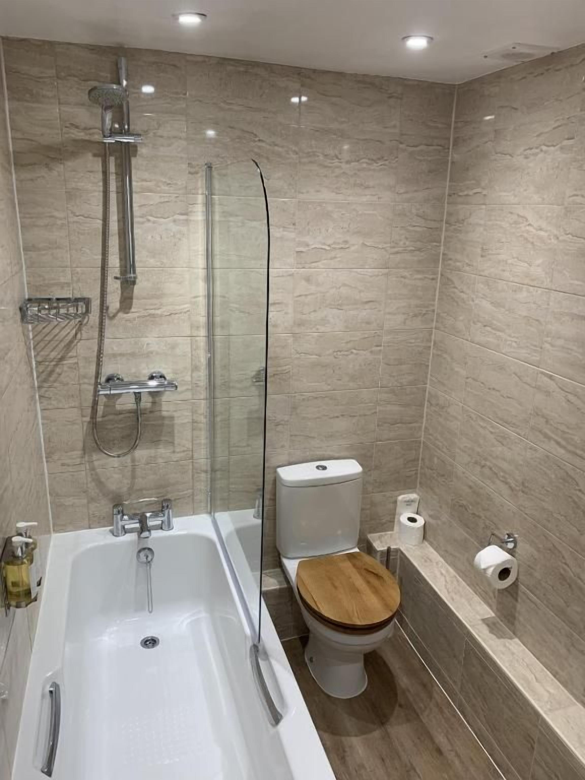 Un baño moderno con bañera, inodoro y ducha.